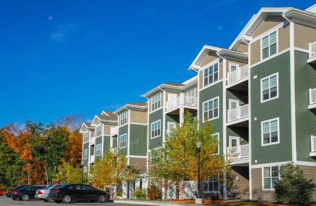 Modern apartment building with parked cars outside.