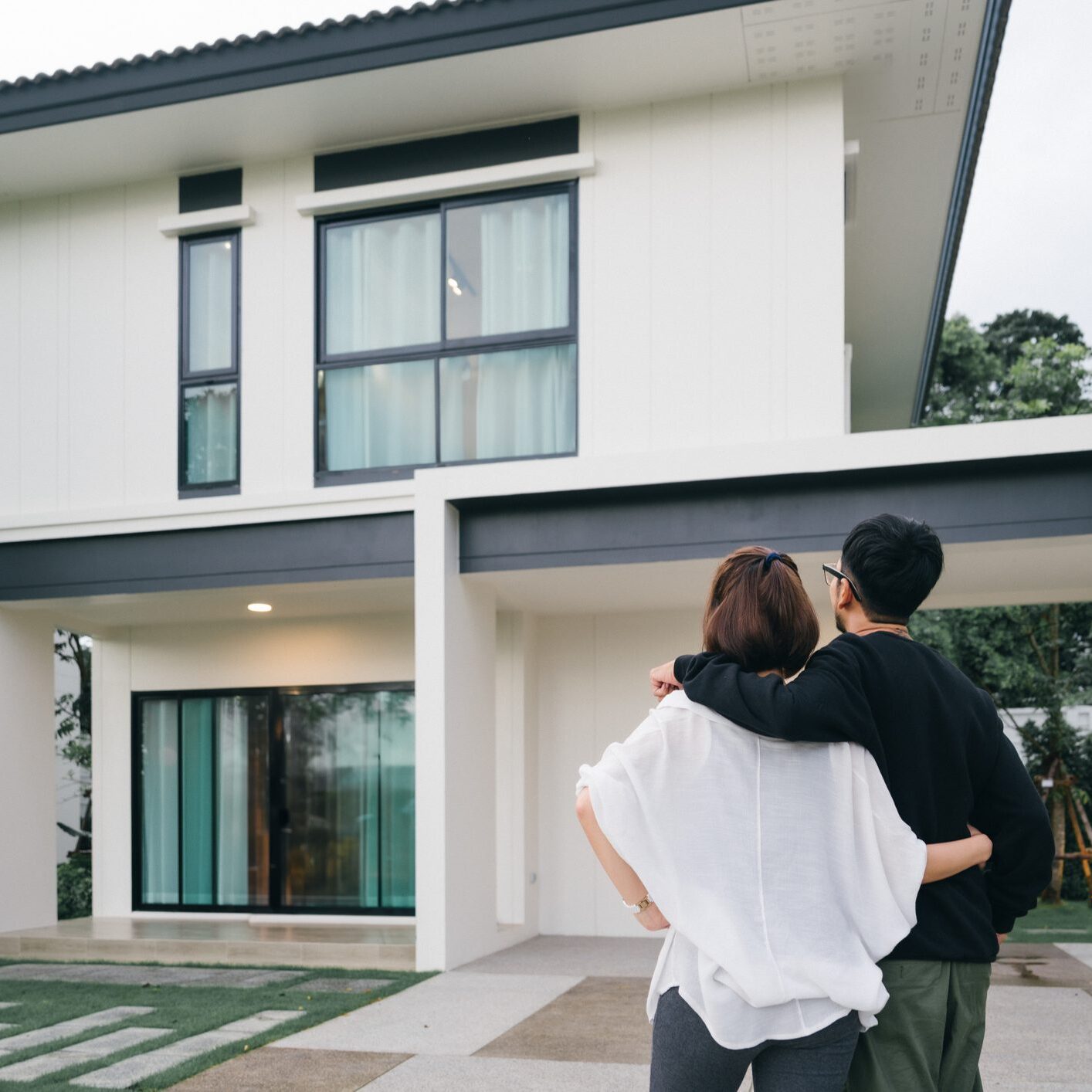Happy Asian Couple Proudly Embracing Their New Home